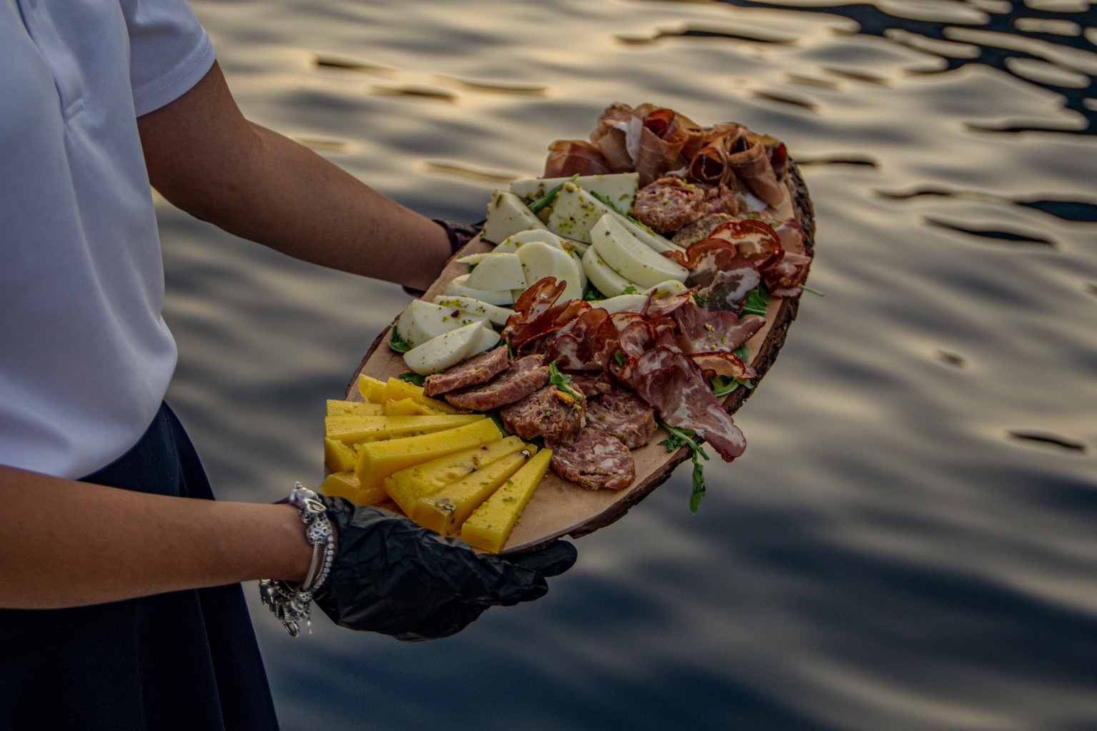 A wooden board with a selection of cured meats and cheeses