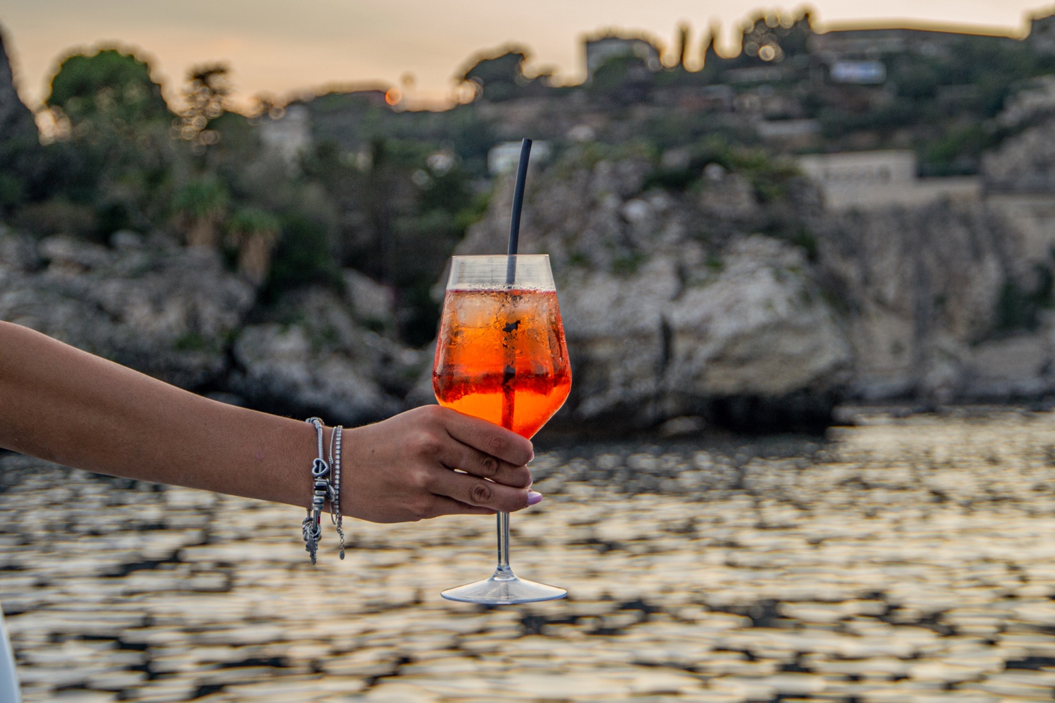 An Aperol Spritz served by the sea at sunset